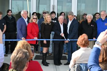People cutting a ribbon for a new building