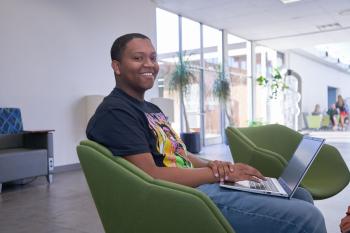 A student sits in a chair in the OMNI building at ChattState with a computer on his lap. A student sits in a chair in the OMNI building at ChattState with a computer on his lap.