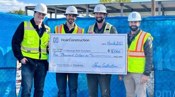 4 men holding a giant size check