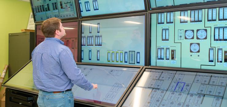 A man looks at a simulated nuclear control room.