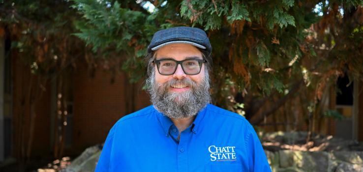 A bearded man in a wool hat smiles.